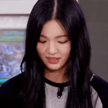 a woman with long black hair is making a funny face with her eyes closed