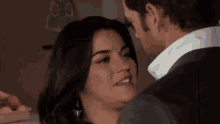 a man in a suit and a woman in a white shirt are kissing .