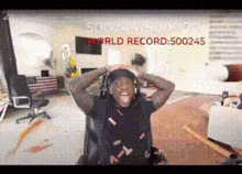 a man wearing headphones is sitting in a chair in a living room with his hands on his head .