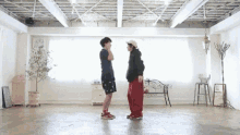 two people are standing next to each other in a large room