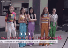a group of girls standing next to each other with the words " the members struggle to watch their colleague working " in the corner