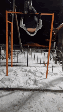 a man is doing a handstand on a bar in the snow