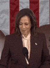 a woman is standing in front of a microphone and smiling .