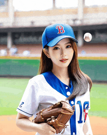 a woman wearing a blue hat with the letter b on it is holding a baseball