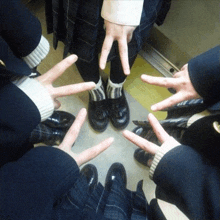 a group of people giving the peace sign with their hands
