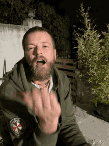 a man with a beard is wearing a hoodie with a patch that says umbrella corporation