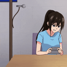 a girl in a blue shirt is sitting at a table playing a game