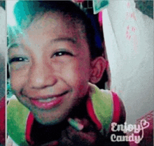 a young boy is smiling with the words enjoy candy on the bottom right