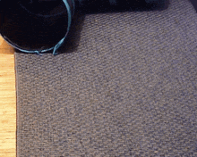 a black object is laying on a gray carpet