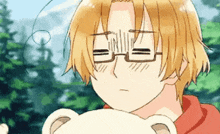 a boy with glasses is holding a teddy bear and making a face .