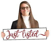 a woman is holding up a sign that says just listed