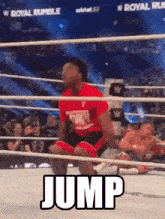 a man is kneeling in a wrestling ring with the word jump written on the ground .