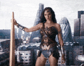 a woman in a wonder woman costume holds a sword in front of a city skyline