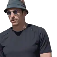 a man wearing a bucket hat and sunglasses looks to his left
