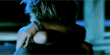a man and woman are hugging each other in the dark .