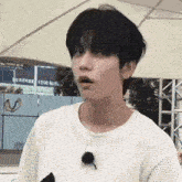 a close up of a person wearing a white sweater and making a funny face .