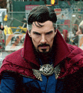 a man with a beard is wearing a red cape and a pendant