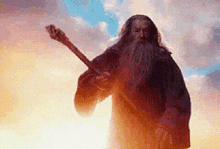 a man with a long beard is holding a sword in his hand .