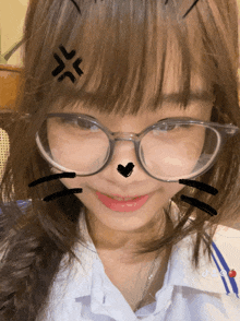 a girl wearing glasses has a drawing of a cat on her forehead