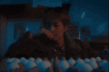 a person sitting in front of a tray of white eggs