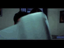 a man and a woman are looking at something in a room