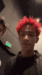 a young man with red hair is standing next to another young man in a room .