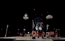 a group of women are dancing in a dark room