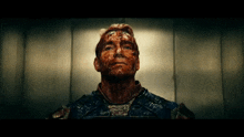a man with blood on his face is looking up at the camera