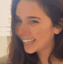a woman is smiling and looking at the camera