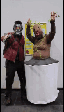 a man in a star lord costume stands next to a man in a tree costume