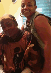 two women are posing for a picture with one wearing an orange shirt that says ' a ' on it