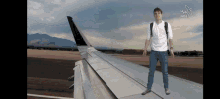 a man standing on the wing of an airplane with the word noe on the bottom right