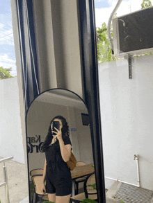 a woman is taking a picture of herself in a mirror with a sign on the wall that says ' ka ' on it