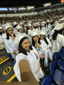 a girl in a graduation cap and gown is wearing a name tag that says ' michigan '