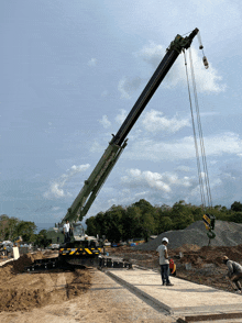 a construction site with a green and black crane that says sanyco