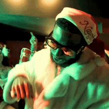 a man wearing sunglasses and a santa hat that says coca cola