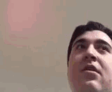 a man is holding a yellow balloon and looking up at the camera .