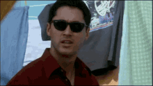 a man wearing sunglasses is standing in front of a t-shirt that says bull