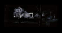 a woman is standing in the doorway of a house at night ..