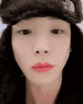 a close up of a person 's face wearing a hat that says the north face
