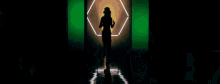 a woman in a hat is dancing in front of green lights