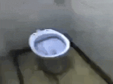 a close up of a toilet in a bathroom with a shadow on the floor .