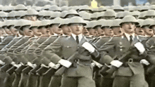 a row of soldiers marching in a line wearing helmets and uniforms