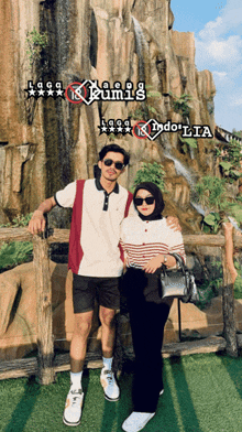 a man and a woman are posing for a picture in front of a waterfall with the word indonesia on the bottom
