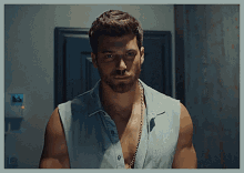 a man with a beard is wearing a sleeveless shirt and a chain around his neck