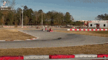 a person is riding a go kart on a track with trees in the background
