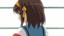 a girl with brown hair and a yellow bow on her head