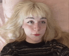 a woman with blonde hair and freckles is wearing a black shirt