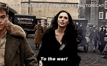 a man and a woman are walking down a street . the woman is saying `` to the war '' .