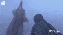 a blurred image of two people with flixier in the corner